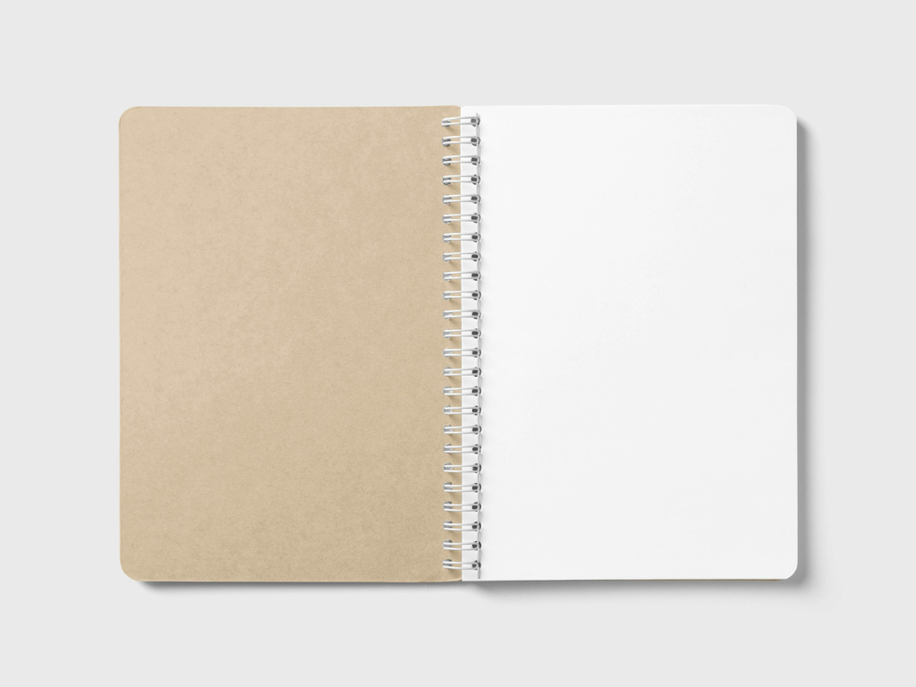 Ein geöffnetes Notizbuch mit Spiralbindung, das links eine braune, unbeschriebene Kartonabdeckung und rechts eine leere, weiße Seite zeigt.