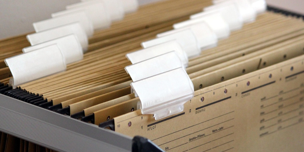 Nahaufnahme einer Hängeregistratur mit dicht hintereinander hängenden, braunen Aktenmappen und leeren Sichtreitern.